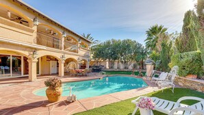 A pool area with a stone patio, lounge chairs, and a decorative vase. - Private Pool, Grill & Fenced Yard: Las Vegas Home (Las Vegas)