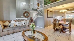 A spacious living area with a high ceiling, a staircase, and a dining area with wooden furniture. - Private Pool, Grill & Fenced Yard: Las Vegas Home (Las Vegas)