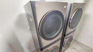 Deux machines à laver LG, fixées au mur, dans une pièce dont le sol est recouvert de carrelage.