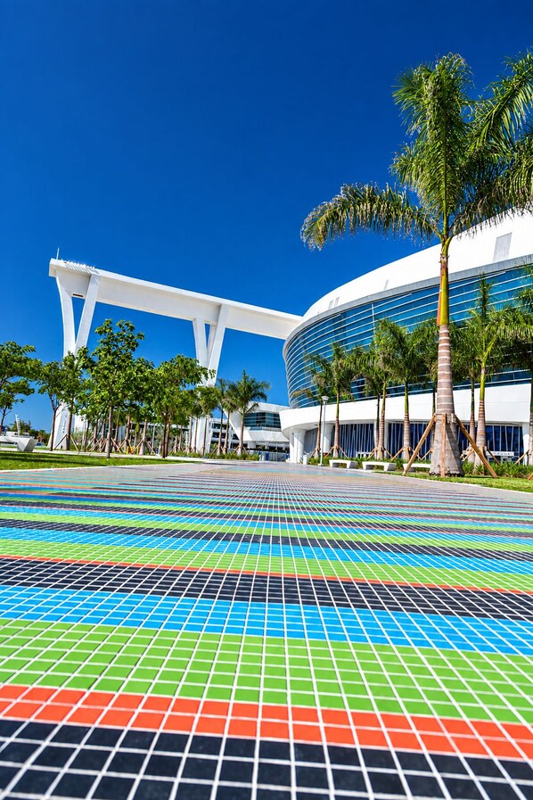 A modern building with a curved facade and a white structure in front.