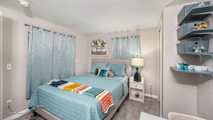 Une chambre à coucher avec un lit, une table de chevet et des étagères.