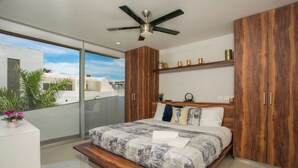 A modern bedroom with a bed, wooden wardrobe, and a ceiling fan. - Your Home Away: Rooftop Pool Close to Beach & Fun (Playa del Carmen)