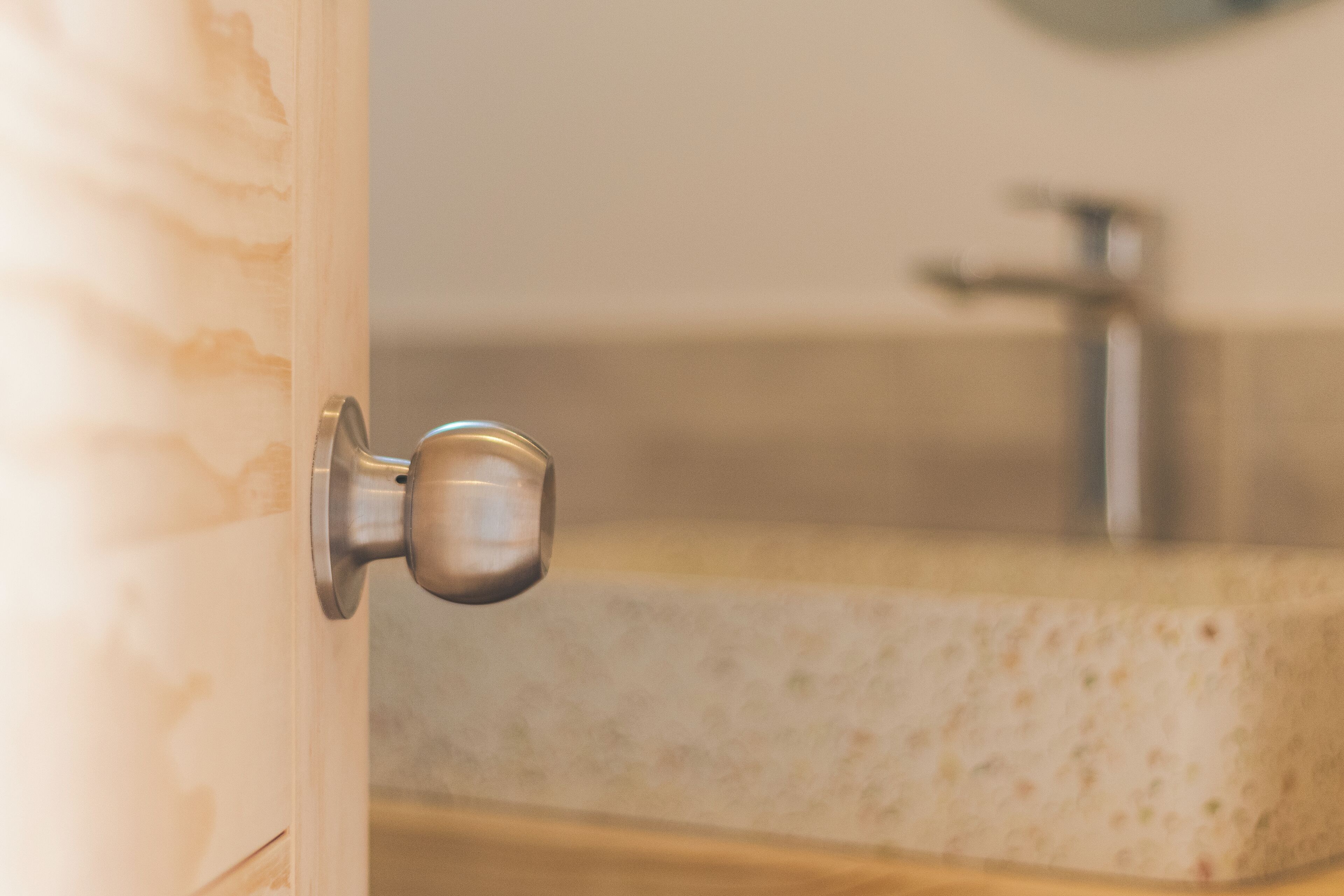 Un baño con lavamanos de mármol y pomo metálico.