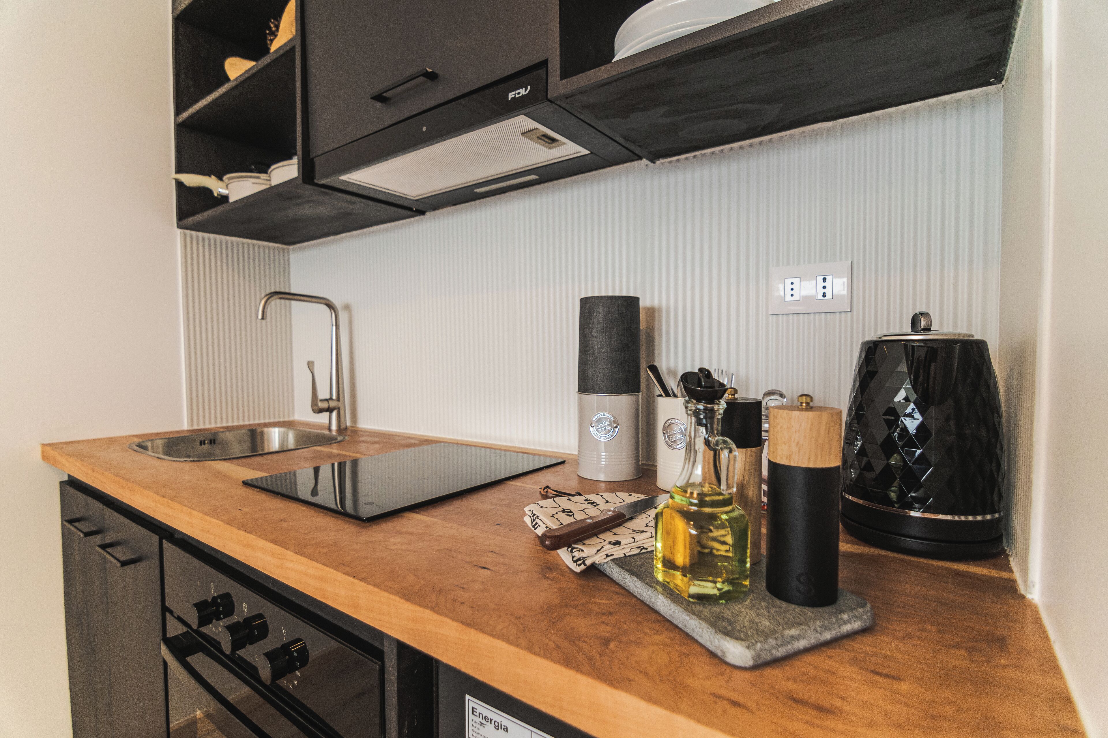 Een oven, een waterkoker, kookgerei, borden en bestek