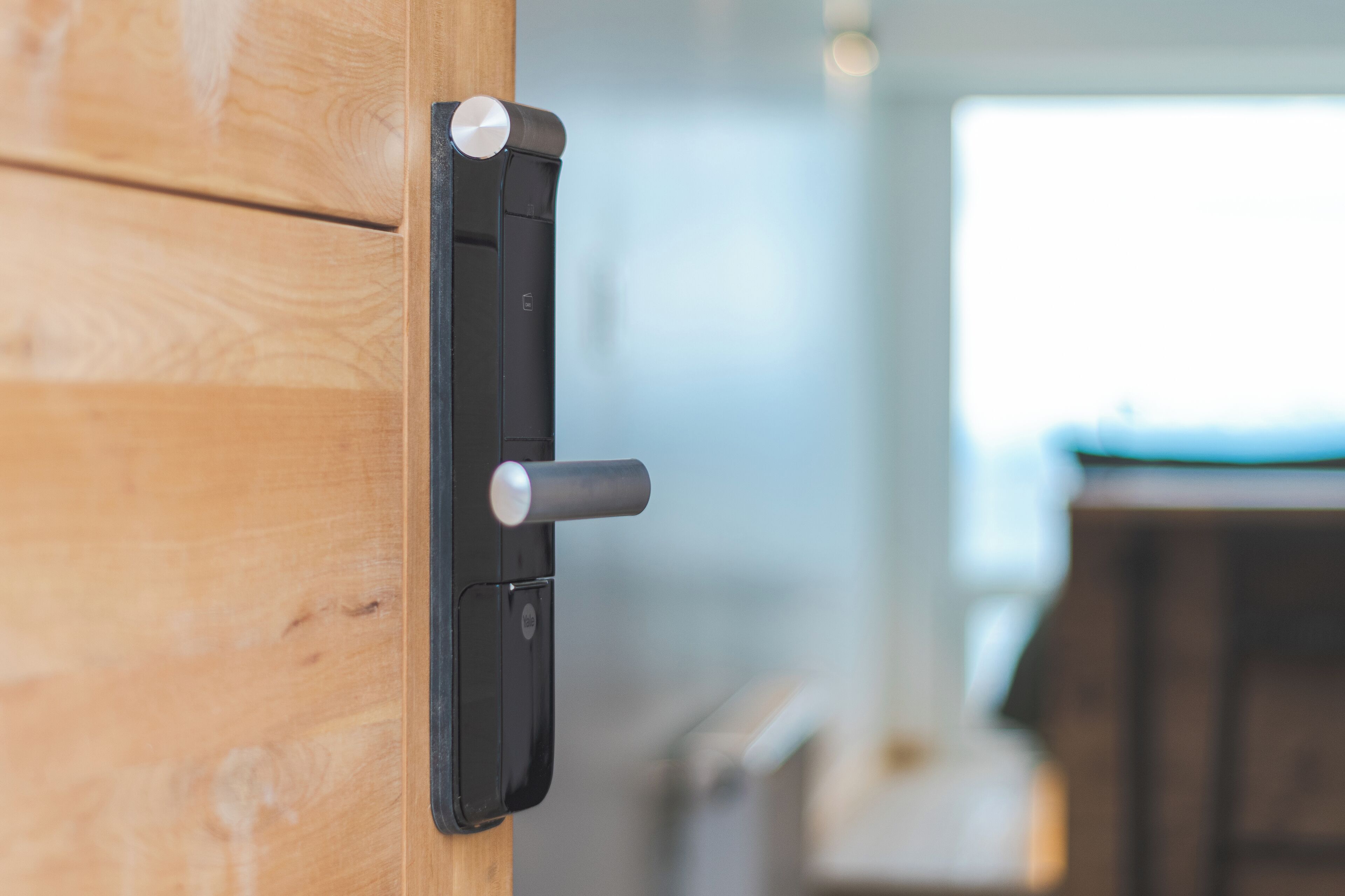 Una puerta de madera con una cerradura electrónica negra moderna.