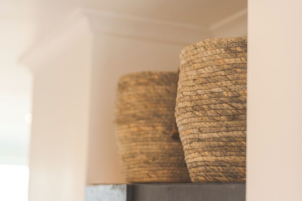 Two woven baskets on a shelf.