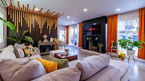 Una sala de estar moderna con un sofá, una mesa de centro y un televisor montado en la pared.