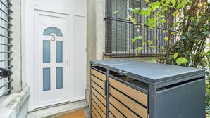 Una porta bianca con un vetro e un cancello metallico a destra.