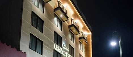 Un hotel con una facciata moderna, diversi balconi e un cartello ben visibile.