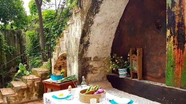 A table set outdoors with a rustic stone wall in the background. - The Sicilian (Acireale)
