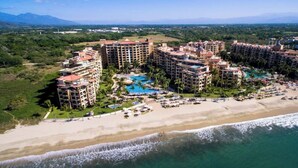 A resort with multiple high-rise buildings, a beachfront, and a pool area.