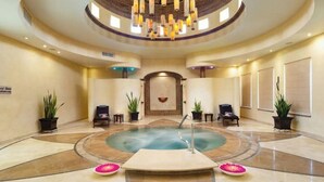 A spa area with a central hot tub, seating around it, and a decorative ceiling.