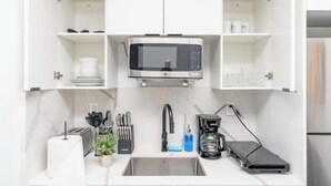 A modern kitchen with a built-in microwave, a sink, and a coffee maker. - King Bed brand new safe Oasis minutes to Brickell (Miami)