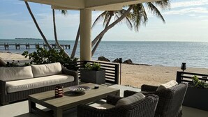 A covered outdoor seating area with wicker furniture and a view of the ocean. - Beautiful ocean front private beach 2-bedroom house gorgeous views Isla morada  (Islamorada)