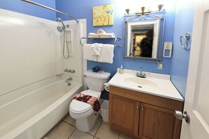 A bathroom with a bathtub, toilet, sink, and wooden vanity. - Beachwood Condos& Resort, Ocean Side Condo with 1 King Bed & Kitchen near beach (Copalis Beach)