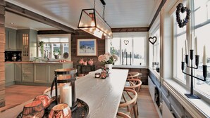 A spacious kitchen with a central island, wooden cabinets, and a large window with heart-shaped decorations.