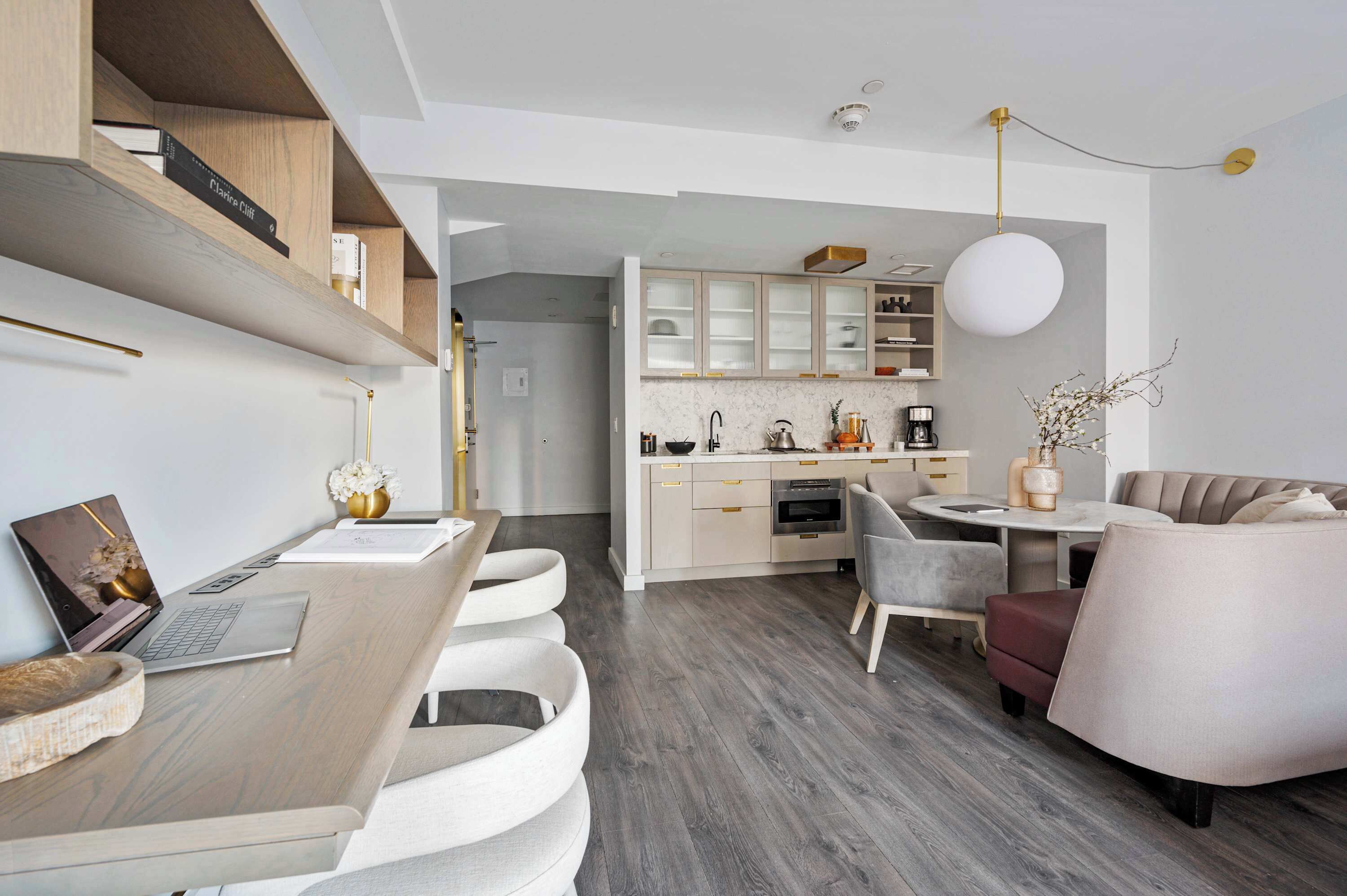 A modern kitchen with integrated dining area, built-in cabinets, and a round dining table.
