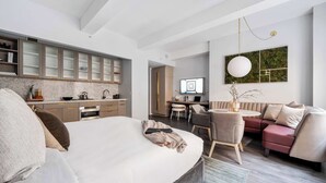 Quarto moderno com cama grande, escrivaninha e sofá.