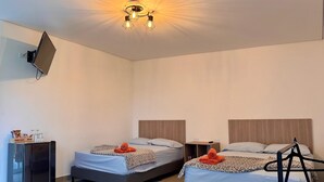 A hotel room with two beds, a TV mounted on the wall, and a ceiling light fixture. - CABIN WITH JACUZZI AND POOL PEÑOL GUATAPE  (Antioquia)