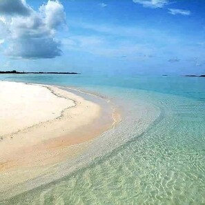 Een strand met helder ondiep water en een zandstrand.
