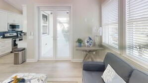 A modern kitchen with white cabinets, a microwave, and a toaster. There is a gray sofa with a decorative pillow and a small table with a plant and a starfish decoration. - Treasure Cay Getaway with BOAT DOCK!
4 bedroom, pool, & bbq Cabana (Treasure Cay)