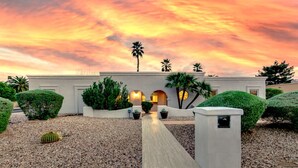 A modern building with a pathway leading to an entrance, surrounded by well-maintained landscaping and palm trees. - Scottsdale Vacation Home Near Kierland|Heated Pool & Games (Scottsdale)