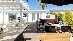 A patio with white chairs, a wooden table, and a grill. - Best OldTown Scottsdale Location|Heated Pool|Spa (Scottsdale)