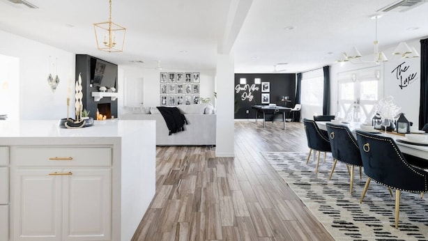 A modern kitchen with white cabinetry, a central island, and a dining area with a black and white patterned rug. - Best OldTown Scottsdale Location|Heated Pool|Spa (Scottsdale)