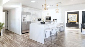 A modern kitchen with white cabinetry, stainless steel appliances, and a central island with bar stools. - Best OldTown Scottsdale Location|Heated Pool|Spa (Scottsdale)