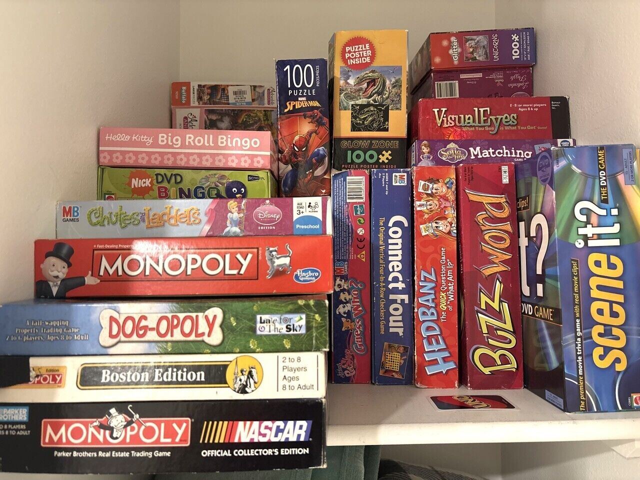 A shelf with various board games and puzzles.
