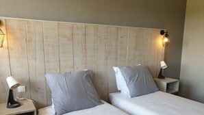 A hotel room with two beds, wooden headboard, bedside lamps, and a wall-mounted light fixture. - Auberge Bois de étang Motel les Tilleuls (Peyrat-le-Château)