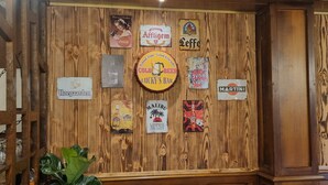 A wall with various vintage signs and logos, including brands like Coca-Cola, Affligem, and Havana Club. - Auberge Bois de étang Motel les Tilleuls (Peyrat-le-Château)