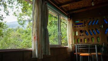 Una habitación con un ventanal grande, techo de madera y una pared decorada con formas de botellas.