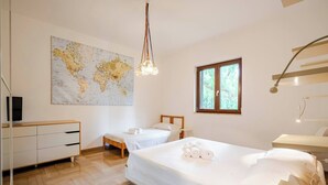 A hotel room with two beds, a wooden dresser, a map on the wall, and a window with natural light. - Massaroom (Conversano)