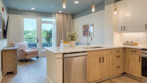 Una cocina moderna con armarios de madera, lavavajillas y una isla grande con pileta.