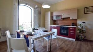 Una cocina compacta con comedor, vistas por una ventana y una planta en maceta.