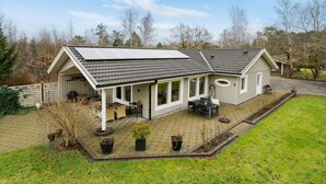 A house with a covered patio, solar panels, and a fenced yard. - Amazing home in Højslev with sauna (Højslev)