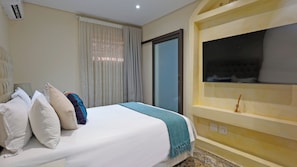A hotel room with a bed, pillows, a TV on the wall, a window with curtains, and a door. - Qurtuba Resort And Events (Johannesburg)