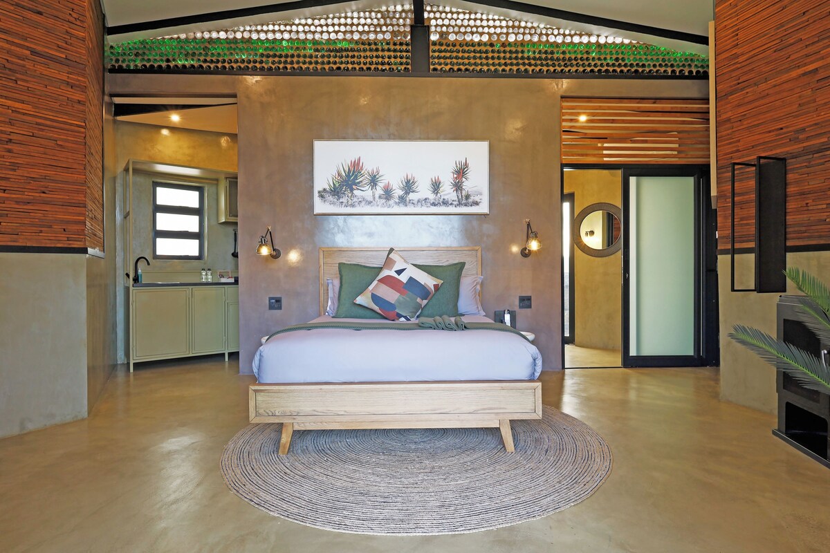 A modern bedroom with a wooden bed, a round rug, and a wall-mounted artwork.