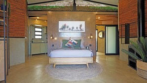 Une chambre à coucher moderne avec un lit en bois, un tapis rond et une œuvre d’art accrochée au mur.