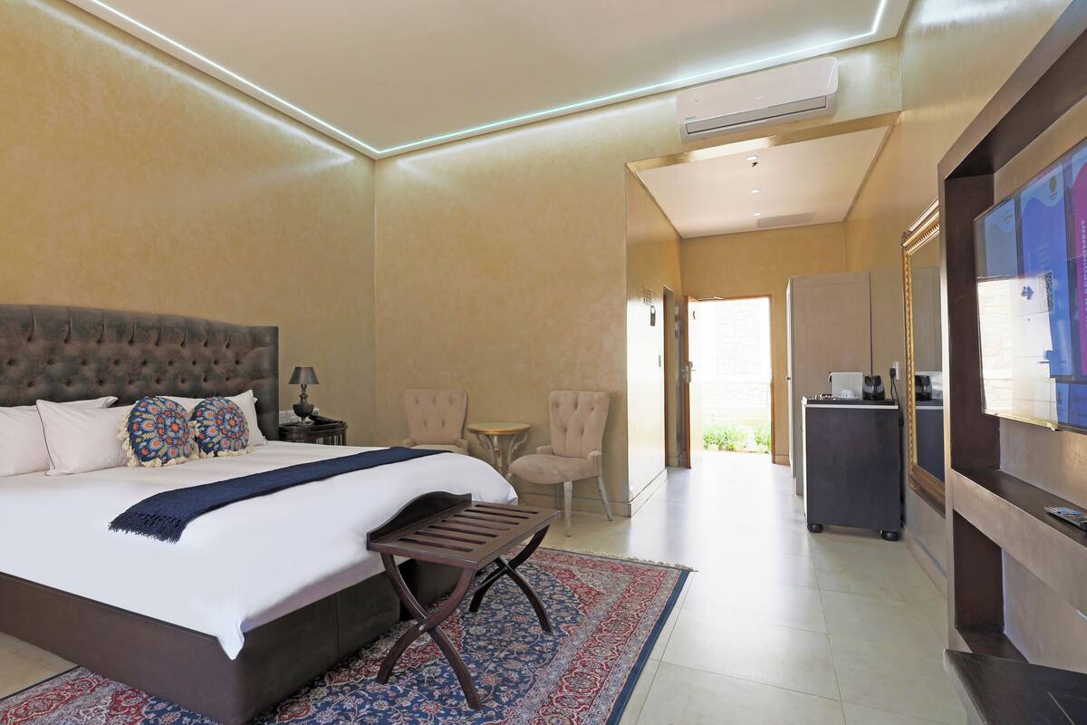 Una camera d'albergo con un letto grande, una scrivania, una sedia e una televisione.