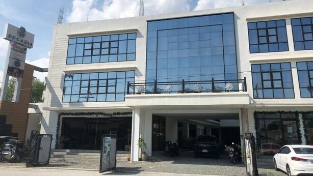 A modern building with a two-story structure, large windows, and a covered entrance area. - RedDoorz @ Occazia Hotel Pampanga (Bacolor)