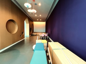 Un intérieur moderne avec une longue table, des chaises et un écran de projection.