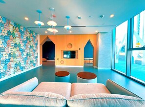 A modern interior with a colorful wall, a large window, and a seating area with two sofas.