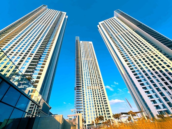 Trois immeubles de grande hauteur se dressent sous un ciel d’un bleu éclatant.
