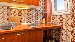 A kitchen with wooden cabinets, a countertop, and a backsplash with a floral pattern. - Amazing apartment in Palit with house sea view (Palit)