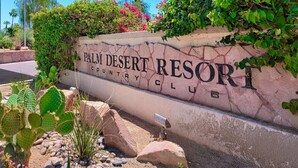 Naamplaatje voor Palm Desert Resort Country Club, met een woestijnlandschap en cactussen.
