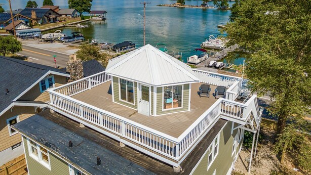 A waterfront property with a covered deck, a dock, and a marina. - Whirlwind Waters Paradise (Russells Point)