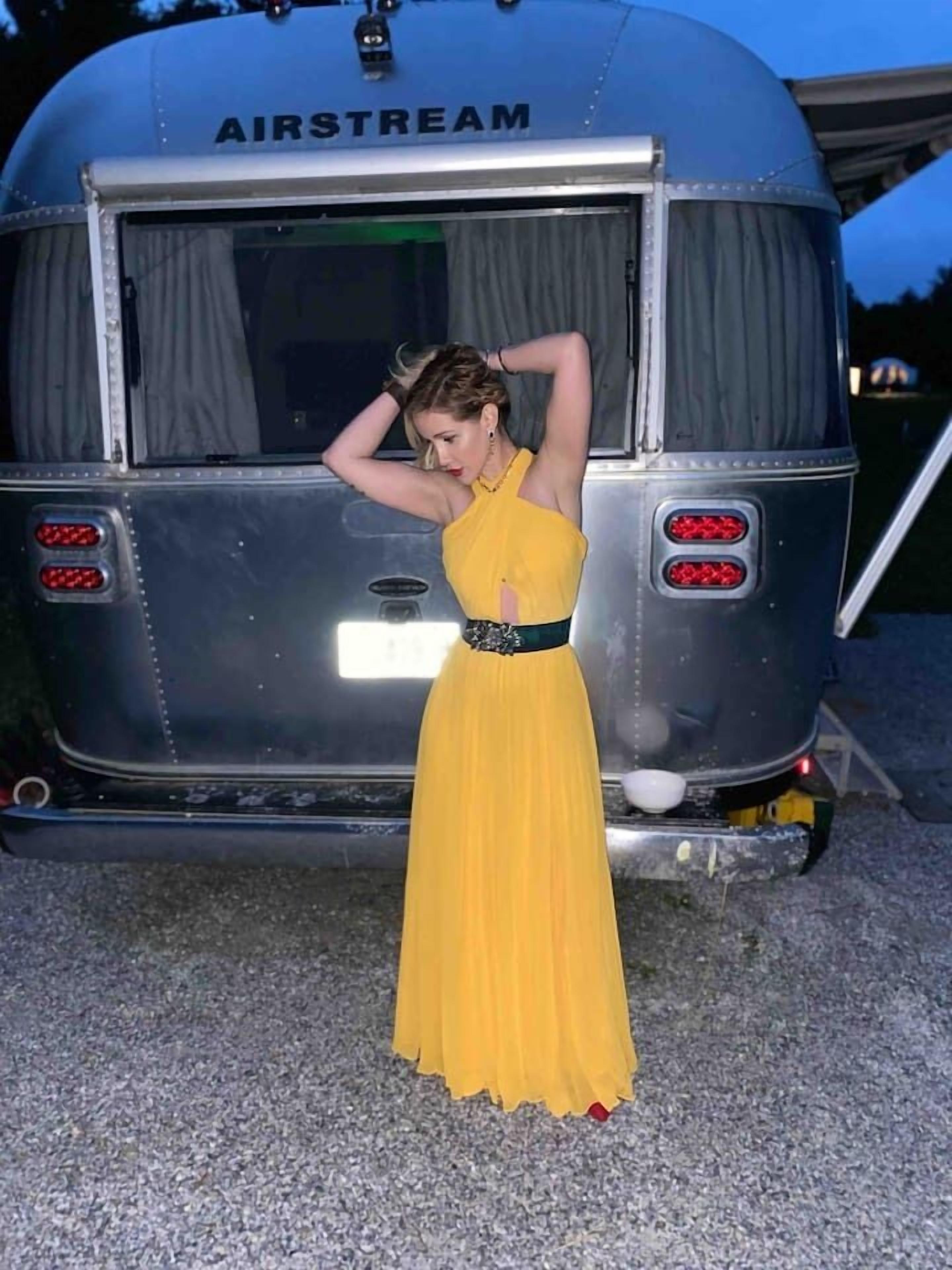 Une personne se tient devant un véhicule portant l’inscription « AIRSTREAM ».