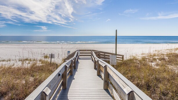 A wooden boardwalk leading to a beach with a clear sky. - Tidewater 801 | Pools, Gym, Hot Tub, Wifi | Private Balcony | Ocean Front Views (Orange Beach)